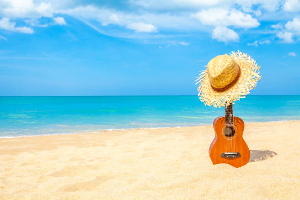 Ukulele on the beautiful summer beach wiht copy space and blue sky stock photo