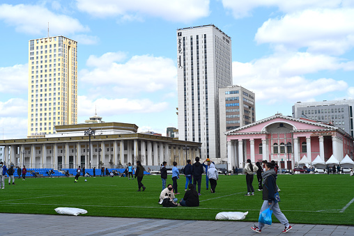 Ulaanbaatar, Mongolia - 11 May 2022: young Mongolian people rest and communicate with each other on a football field in the centre of Sukhbaatar square