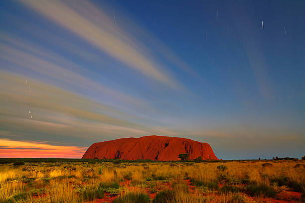 Uluru By Moonlight Northern Territory, Australia - May 18, 2011: Long exposure of Uluru in Australia's Northern Territory. Sunrise is some way off, and the great sandstone monolith is lit by moonlight. megalith stock pictures, royalty-free photos & images