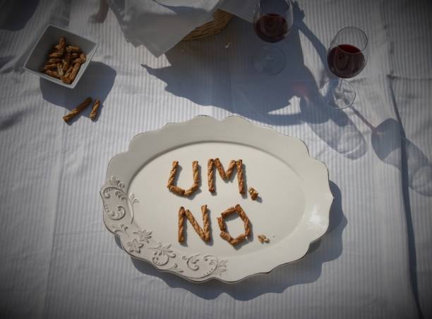 Um...No picnic "Um...No." is spelled out in pretzels on a serving platter with wine glasses and a basket in the background. bad date stock pictures, royalty-free photos & images