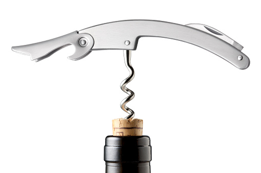 Wine bottle is opened with corkscrew.