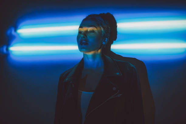 Under the neon lights Portrait of a young woman in a leather jacket posing for a photograph under the neon lights fluorescent light photos stock pictures, royalty-free photos & images