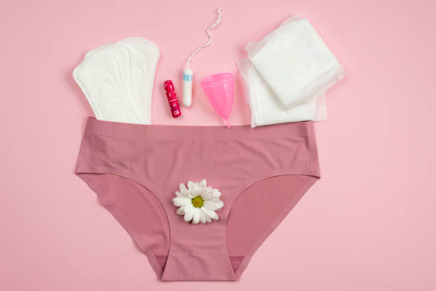 ondergoed met beschermende uitrusting voor kritieke dagen op een roze achtergrond. - menstruatie stockfoto's en -beelden
