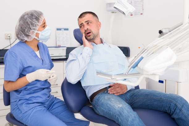 Unhappy american man in medical chair complains of toothache stock photo