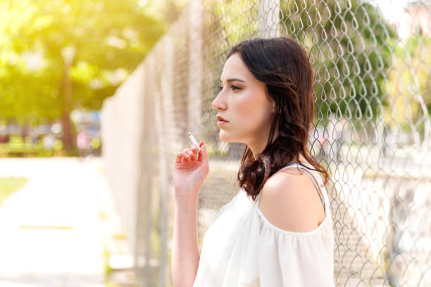 Unhappy girl Thoughtful girl with cigarette - copyspace little girl smoking cigarette stock pictures, royalty-free photos & images