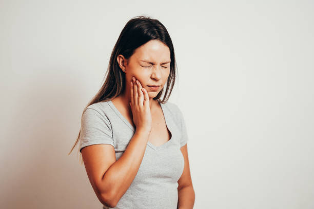 olycklig kvinna känner smärta på tänderna isolerade på grå bakgrund - toothache woman bildbanksfoton och bilder