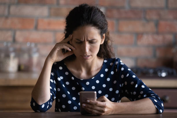 olycklig kvinna använder mobiltelefon missnöjd med gadget problem - bedrägeri telefon bildbanksfoton och bilder
