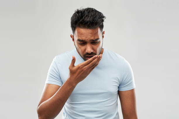 unhealthy indian man coughing health problem and people concept - unhealthy indian man coughing over grey background bad breath stock pictures, royalty-free photos & images