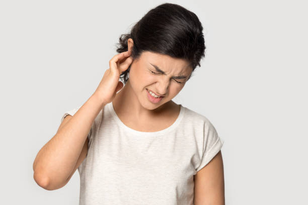Unhealthy indian millennial lady suffering from strong earache. Unhealthy indian millennial lady suffering from strong earache, head shot portrait. Stressed frowning young ethnic girl plugging ear, feeling painful discomfort isolated on grey studio background. uncomfortable photos stock pictures, royalty-free photos & images