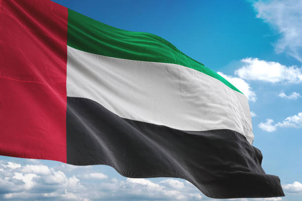 флаг объединенных арабских эмиратов развевается облачным небом - uae flag стоковые фото и изображения