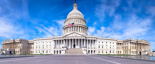 United States Capitol with Flag Flying under Blue Sky stock photo