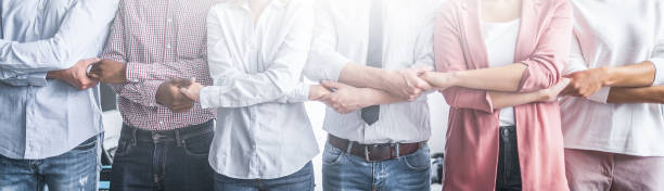 Unity and teamwork concept. Creative team meeting hands together in line. Young business people are holding hands. Unity and teamwork concept. bonding stock pictures, royalty-free photos & images