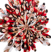 Above view of large group of people joining hands in unity and looking ath the camera. Isolated on white.