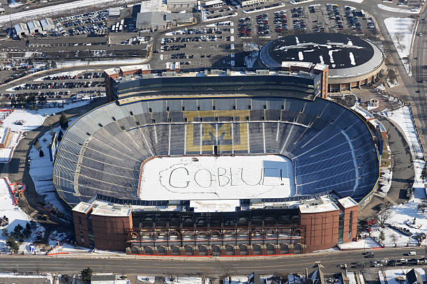 University of Michigan School Spirit Ann Arbor, Michigan USA - December 23, 2009: Aerial view of University of Michigan Stadium with the school spirit slogan written in the snow. michigan football stock pictures, royalty-free photos & images