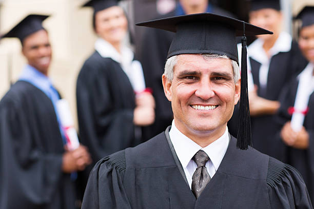 university professor in front of group of graduates stock photo