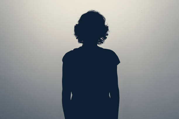 スタジオで不明な女性の人のシルエット。うつ病の概念 - 女性　シルエット ストックフォトと画像