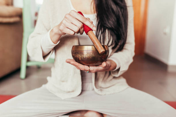 Unknown woman meditating with singing bowl stock photo