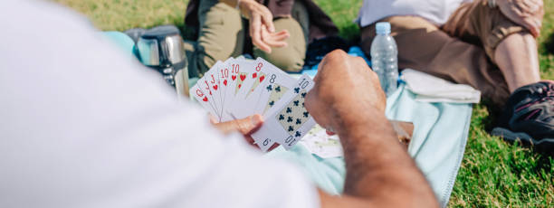 Unrecognizable adult family playing cards during an excursion stock photo