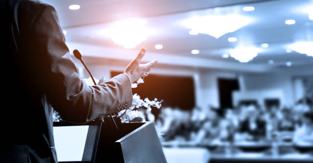 Unrecognizable businessman making a speech in front of audience at conference hall Unrecognizable businessman making a speech in front of audience at conference hall. public speaking stock pictures, royalty-free photos & images