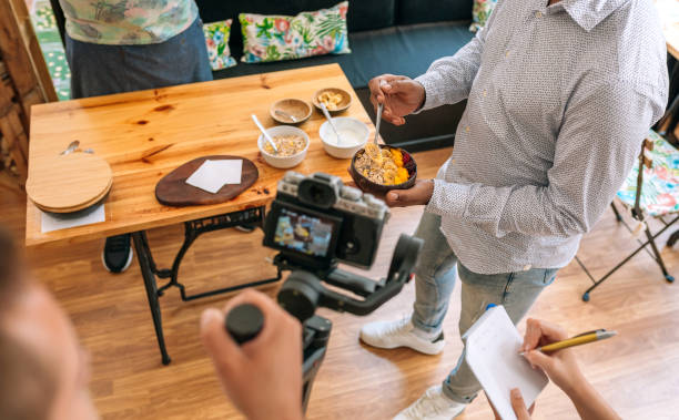 Unrecognizable camera operator recording a streaming cooking tutorial. stock photo