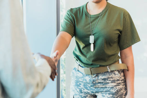 Unrecognizable female soldier greets civilian A confident female soldier greets a bank loan officer with a handshake. military to civilian stock pictures, royalty-free photos & images