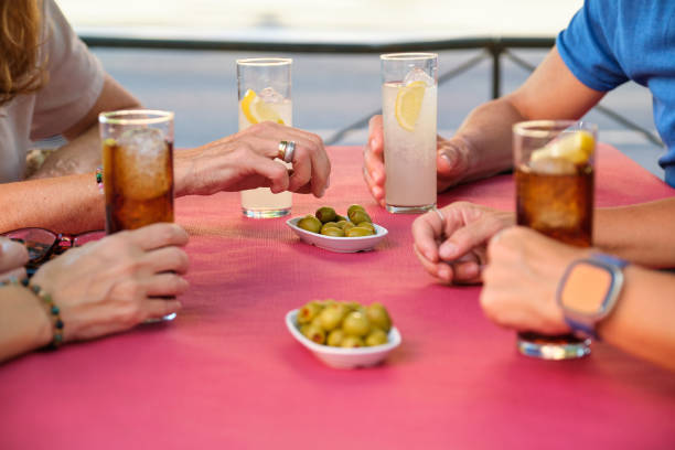 Unrecognizable mature adults drinking and eating olives at a restaurant. stock photo