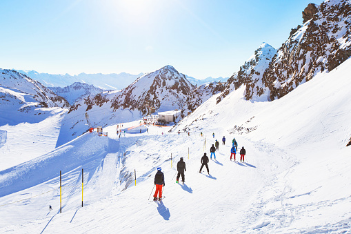 unrecognizable skiers on beautiful ski slope in Alps