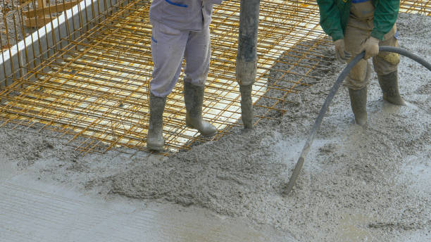 CLOSE UP: Unrecognizable team of workers pours fresh mortar over metal wiring. stock photo