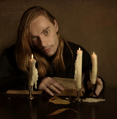 Unshaven Man With Long Blond Hair In A Dark Room Stock Photo