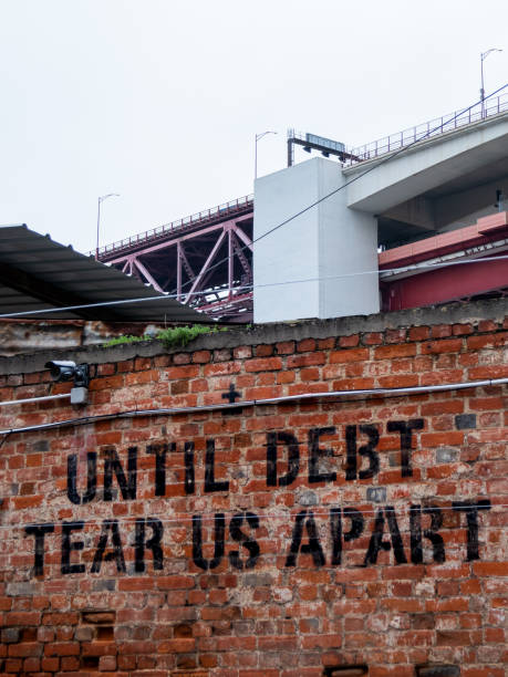 Until debt tear us apart black graffiti stencil on a wall at LX Factory stock photo