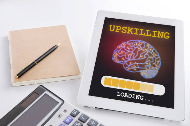 Up skill loading with brain on digital computer tablet on busy working desk stock photo