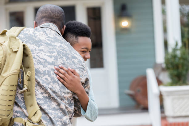 Upset boy tells his army dad goodbye Upset preteen boy gives his military dad a hug as the man leaves for an overseas military assignment. veterans returning home stock pictures, royalty-free photos & images