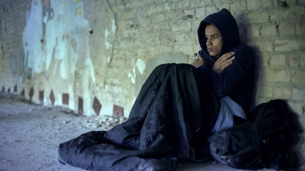 Upset homeless teenager wearing hoodie, feeling cold, indifference and poverty Upset homeless teenager wearing hoodie, feeling cold, indifference and poverty homelessness stock pictures, royalty-free photos & images