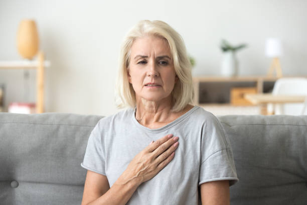 boos benadrukt rijpe oudere vrouw gevoel hartzeer borst aan te raken - borstkas stockfoto's en -beelden