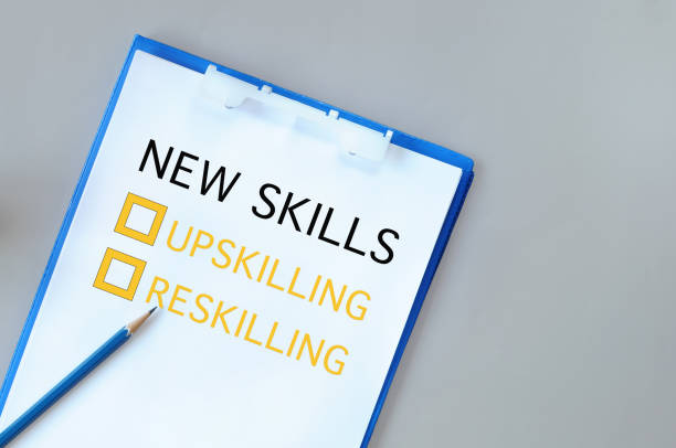 Upskilling and reskilling with check box on notepad with paper and pencil on grey background stock photo