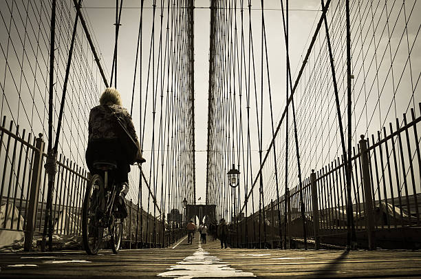 Urban cyclist riding on the Brooklyn Bridge stock photo