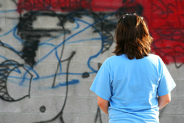 Urban Decline A young girl looking on as her community is hit with graffiti. ugly girl stock pictures, royalty-free photos & images