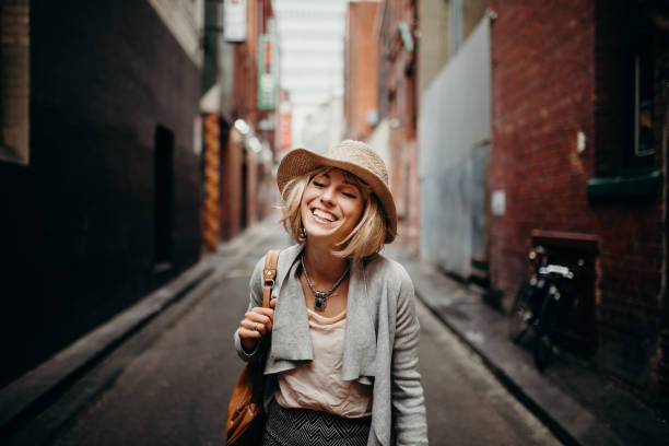 Urban life portrait of smiling woman in the middle of a narrow street. stock photo