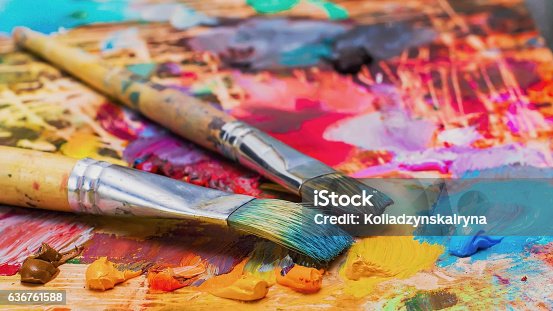 istock Used brushes on an artist's palette of colorful oil paint 636761588