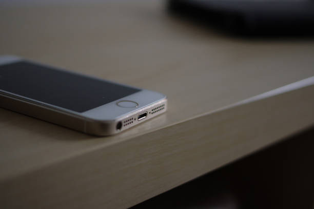 iphone 5 dorado usado con panel blanco e interfaz thunderbolt en mesa de madera de color amarillo claro - iphone mockup fotografías e imágenes de stock