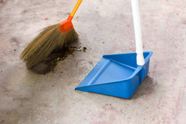 using a broom to sweep the dirt stock photo