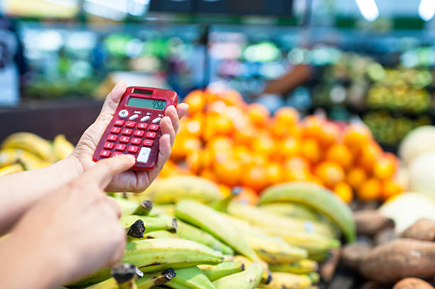 Using a calculator at the supermarket stock photo