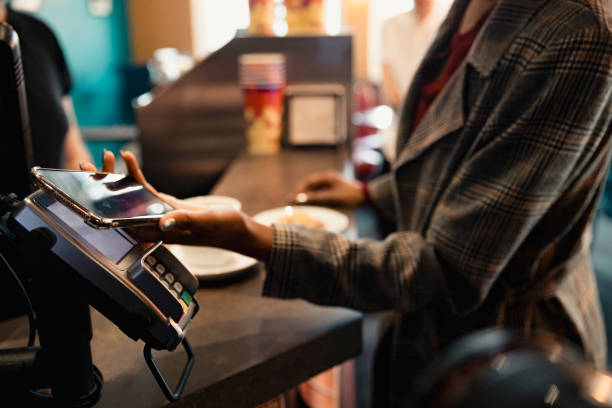Using Contactless to Pay Close-up of a unrecognisable person using their smart phone to pay by contactless. contactless payment stock pictures, royalty-free photos & images