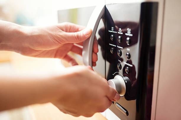 Using microwave oven, close up photo, shallow dof Using microwave oven, close up photo, shallow dof microwave stock pictures, royalty-free photos & images