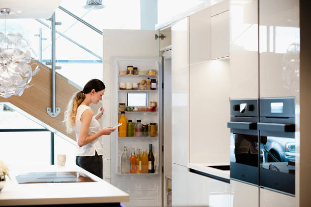 Using My Smart Fridge! A side-view shot of a caucasian woman choosing what healthy snack to get out of her smart fridge. intelligence stock pictures, royalty-free photos & images