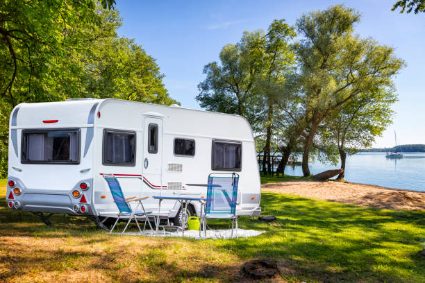 vakanties in polen - camper trailer op de oever van de baai van het meer drawsko - caravan stockfoto's en -beelden