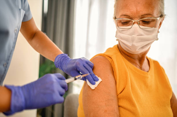 Vaccination as protection against viruses Senior female is about to receive Covid-19 coronavirus vaccine covid 19 vaccine stock pictures, royalty-free photos & images