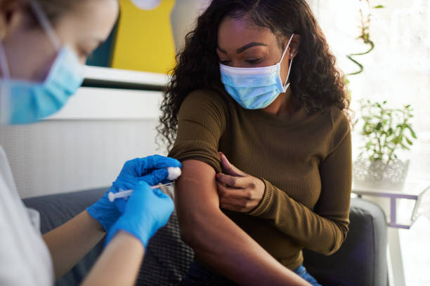 Vaccination At Home. African family get vaccinated at home during pandemic times. preventative medicine stock pictures, royalty-free photos & images