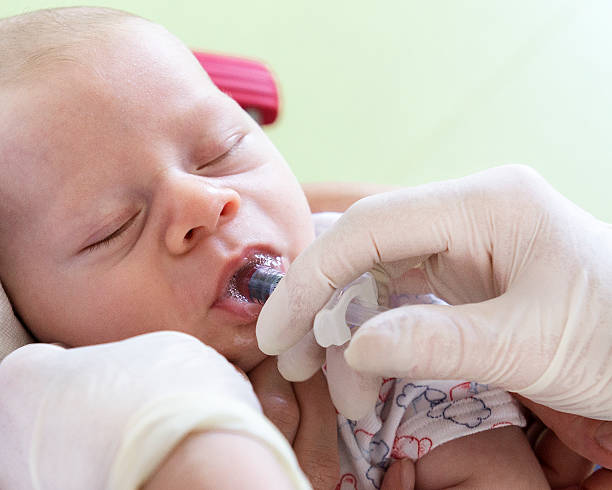 вакцинация, маленький ребенок в врачу в клинику медсестра дает вакцины перорально - polio стоковые фото и изображения