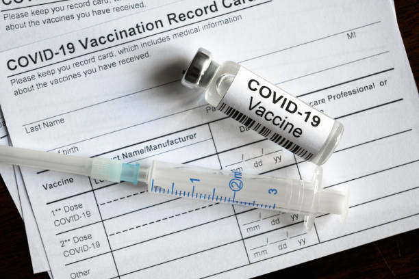ขวดวัคซีนและเข็มฉีดยา COVID-19 อยู่ในบัตรบันทึกการฉีดวัคซีน coronavirus